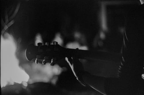 Grayscale Photo of a Person Playing an Acoustic Guitar