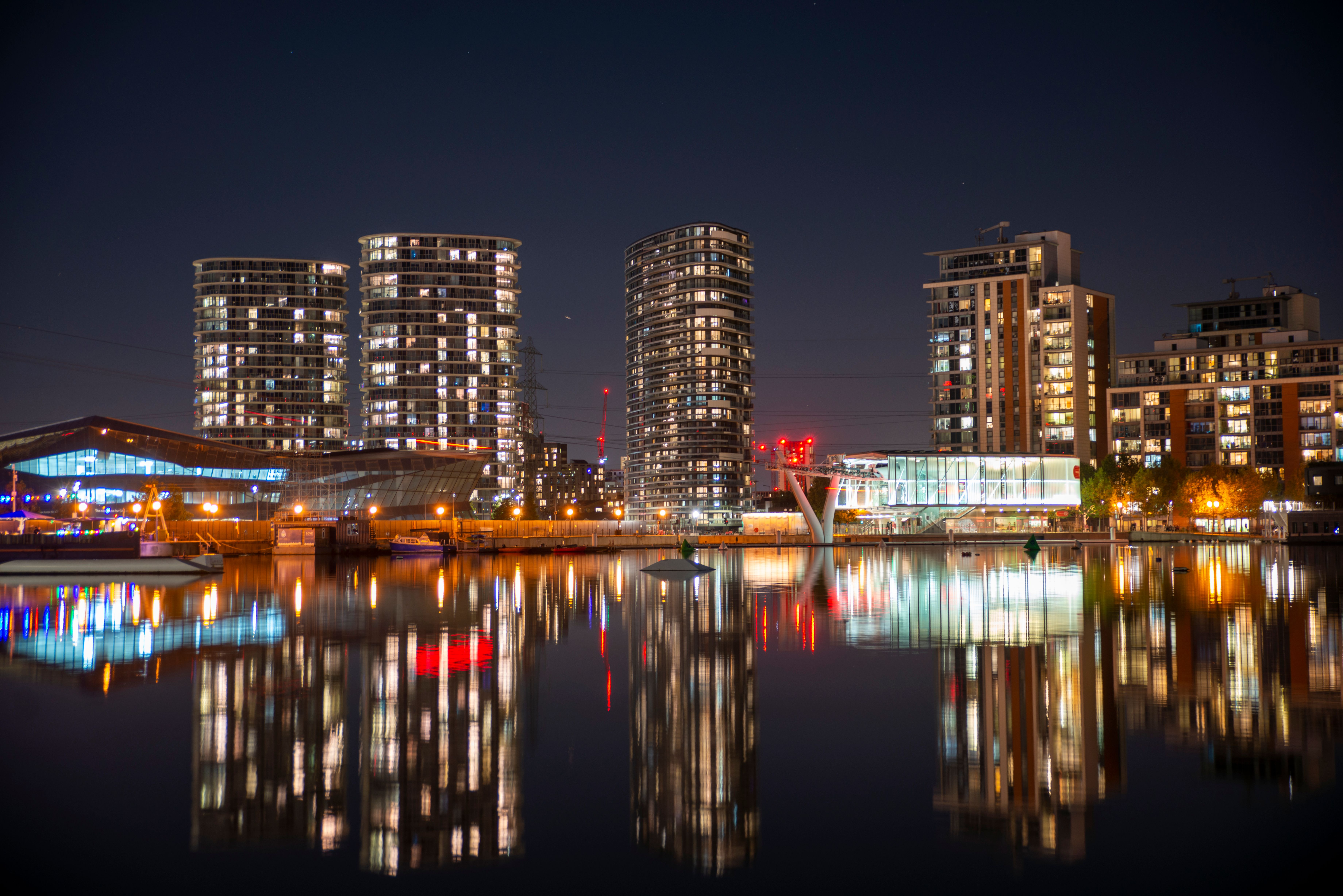 Captivating nighttime view of London's illuminated skyline reflecting on tranquil waters.