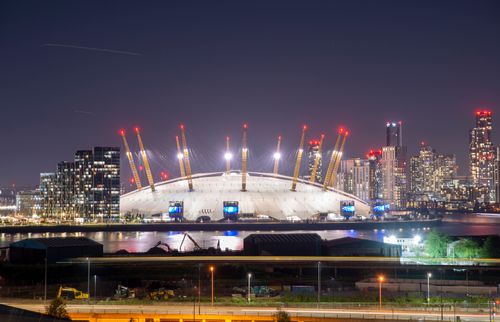 Free Illuminated O2 Arena and London skyline at night showcasing urban architecture. Stock Photo