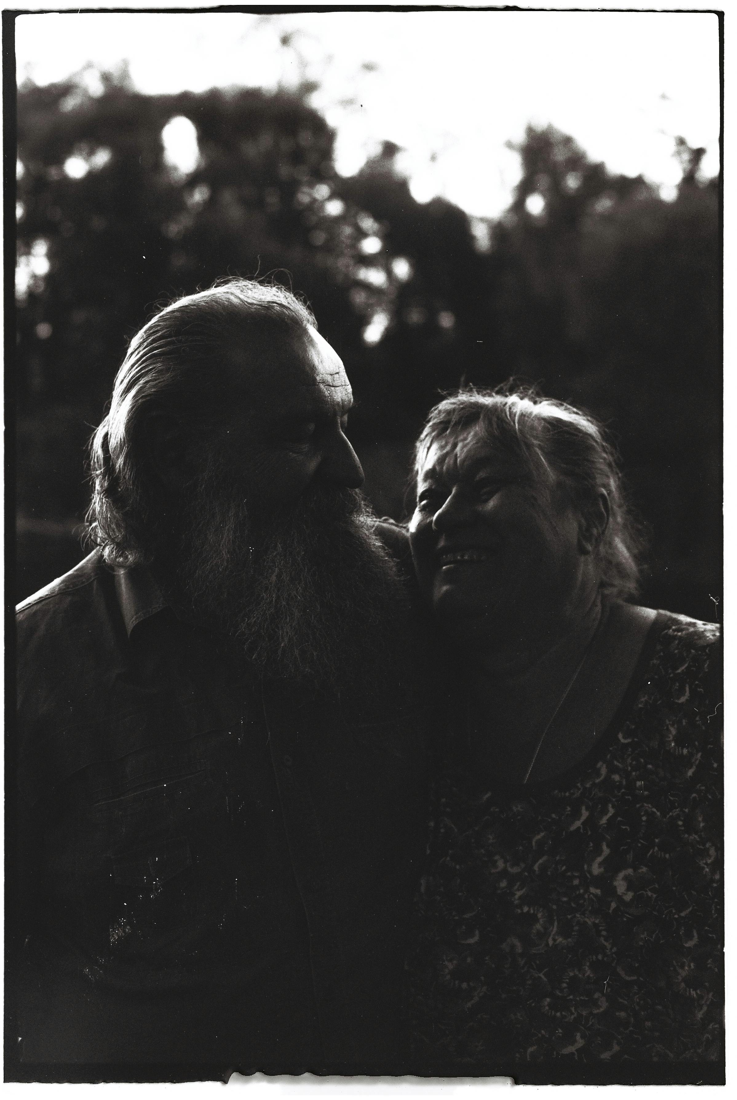Emotive black and white portrait of a smiling senior couple outdoors.