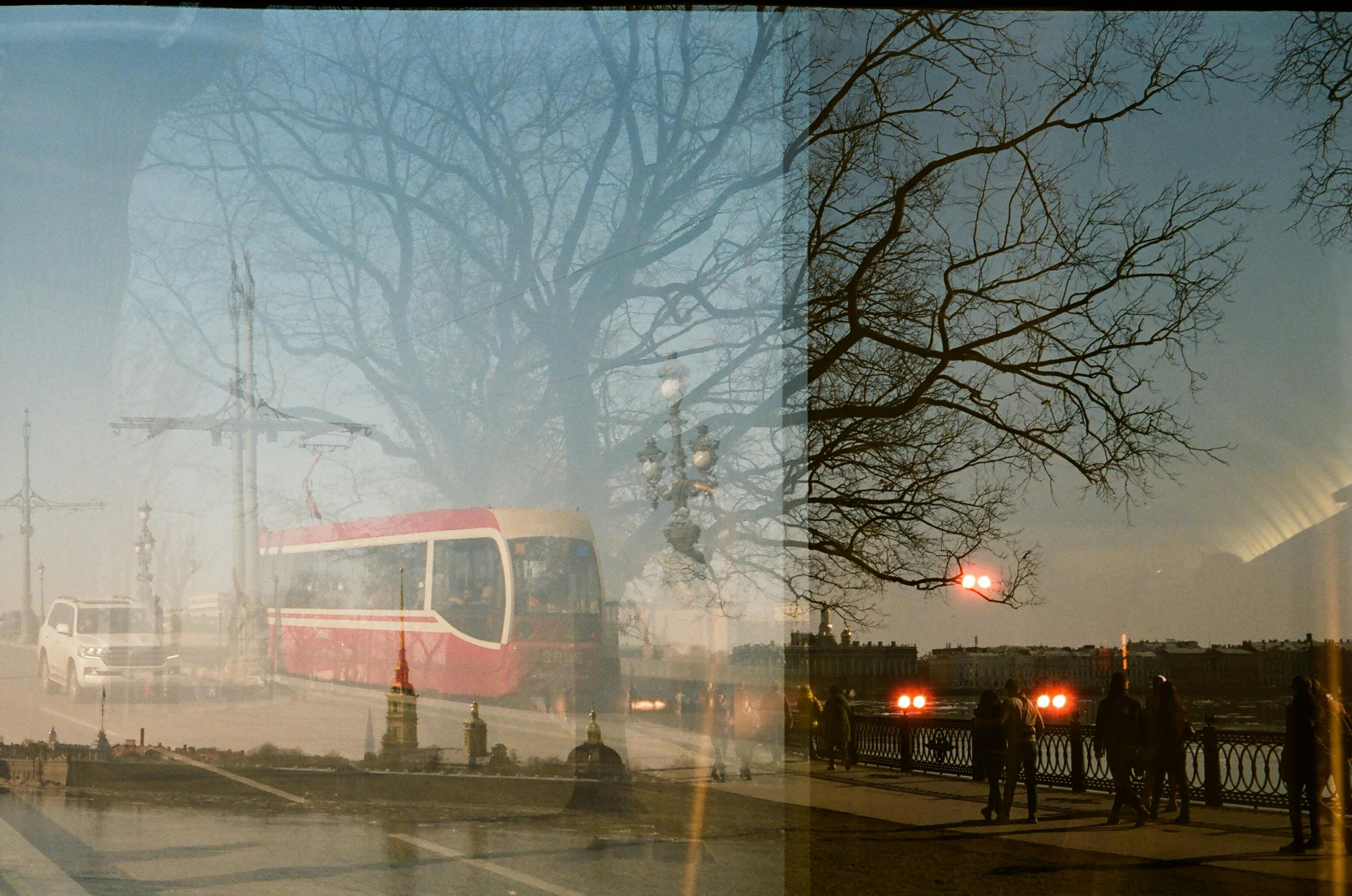 Artistic double exposure of an urban cityscape with a tram and trees in autumn.