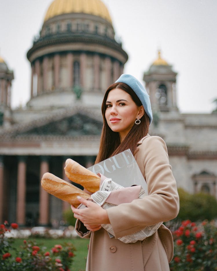 Woman Carrying Baguettes And Vogue Magazine Standing In Front Of Basilica