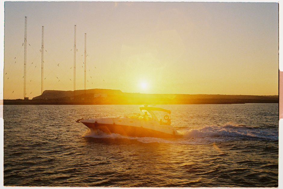 A speedboat glides through the ocean at sunset near Cyprus, capturing the serene beauty of the sea.