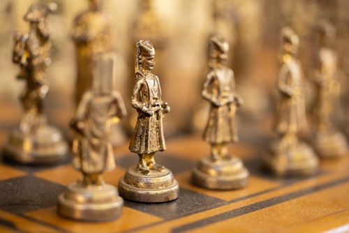 Free Detailed view of vintage chess pieces with a luxurious antique finish on a classic board. Stock Photo