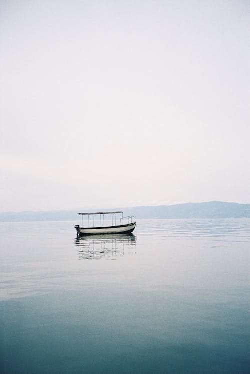 Clear Sky over Small Empty Boat on Lake