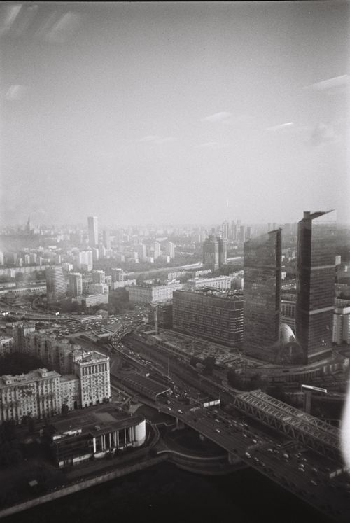 Free Black and white aerial view of a bustling cityscape featuring modern skyscrapers and traffic. Stock Photo