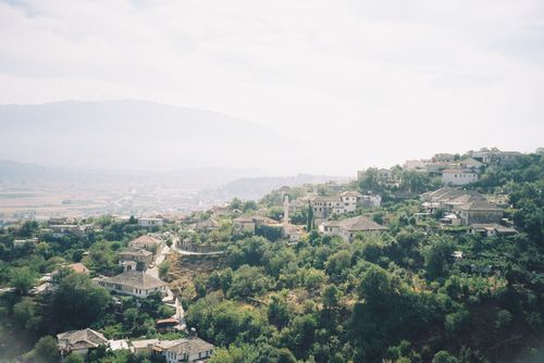 Free Serene view of a lush hillside village under a bright sky, perfect for travel and nature enthusiasts. Stock Photo