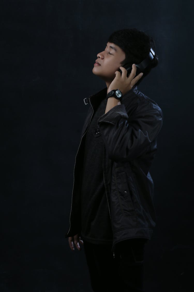 Side View Of A Man In Black Jacket Wearing Headphones