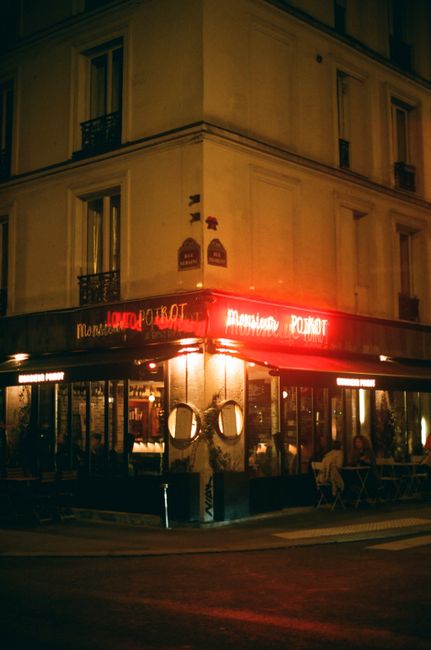 Cozy urban bistro corner with warm neon lights at night, offering an inviting ambiance.