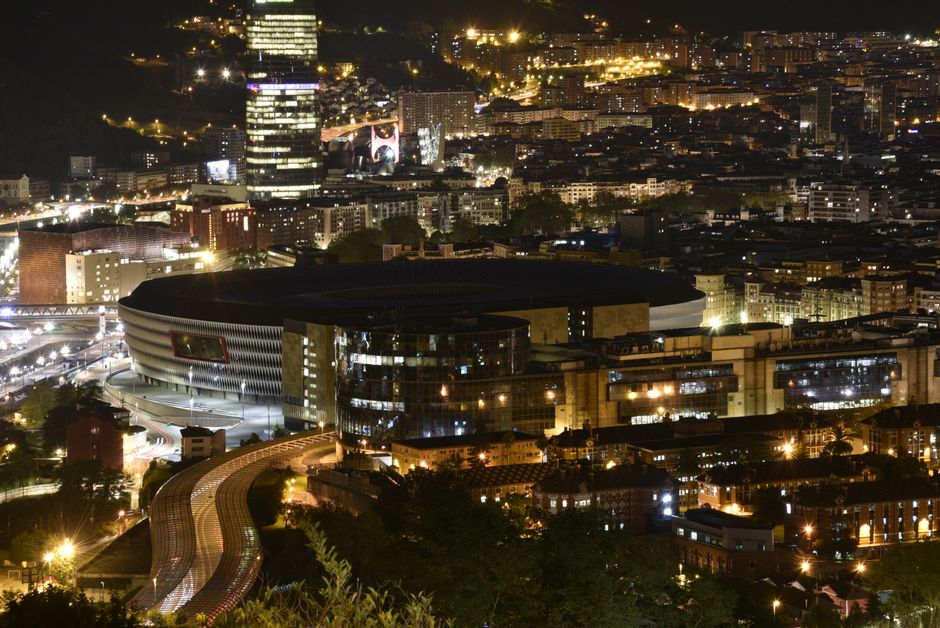 Impresionante vista aérea nocturna de las luces urbanas iluminando edificios altos y calles bulliciosas.