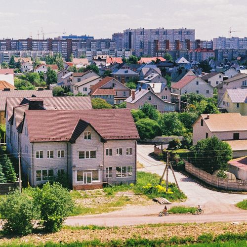 Free A picturesque suburban area with houses in the foreground and city buildings in the background. Stock Photo