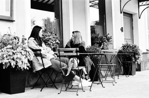 Free Two women having a conversation outside a cafe in Moscow, captured in classic black and white. Stock Photo