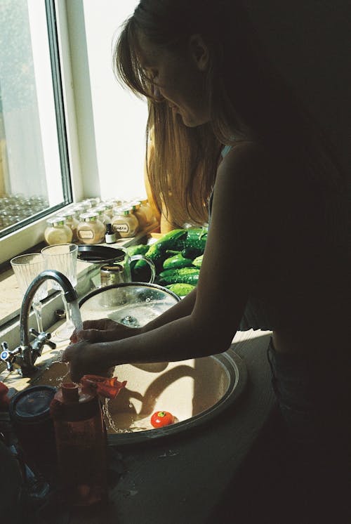 Free A Woman Washing Fresh Vegetables in the Kitchen Sink Stock Photo