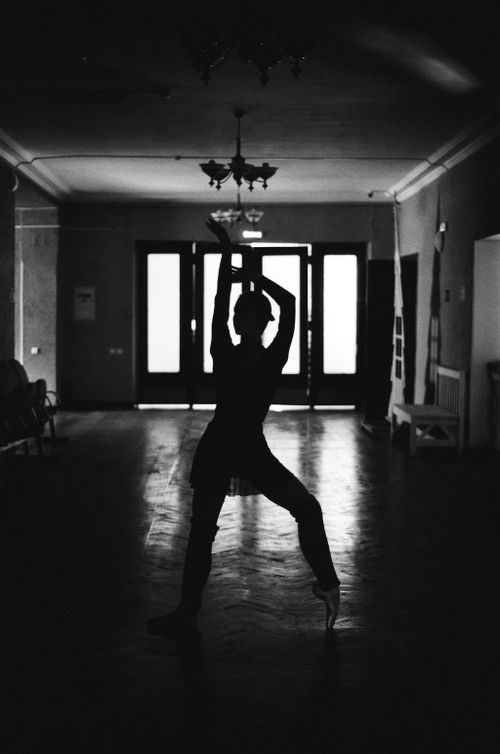 Free Monochrome silhouette of a dancer striking an elegant pose indoors. Stock Photo