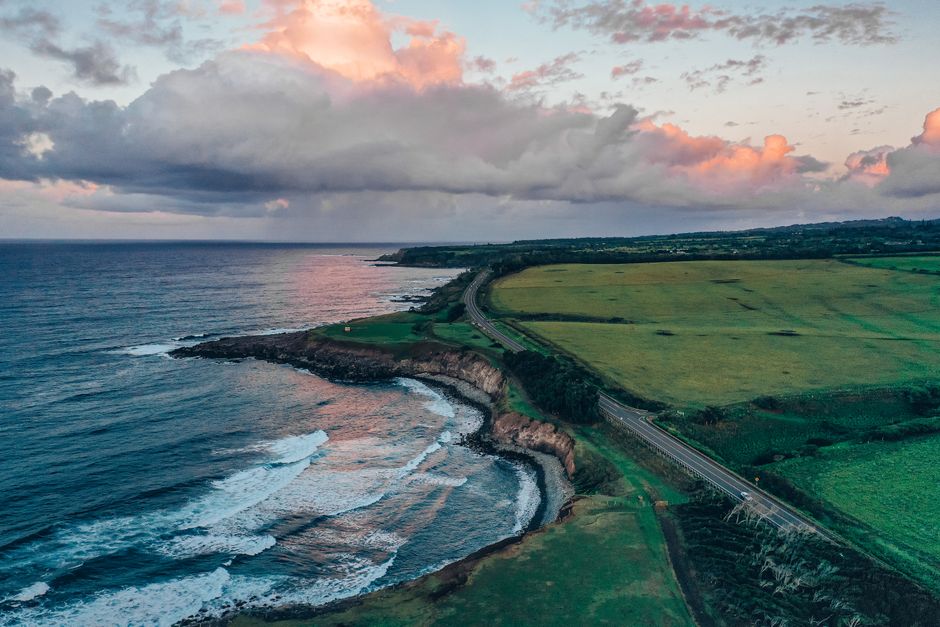 Breathtaking Waterfalls of West Maui and Molokai Helicopter Tour Review: An Unforgettable 50-Minute Adventure Review 2026 - Breathtaking aerial view of a coastal landscape with lush greenery and a dramatic sky at sunset.