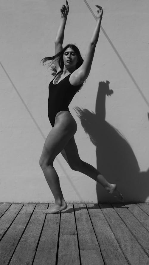 Grayscale Photo of Woman in Black Bodysuit Dancing