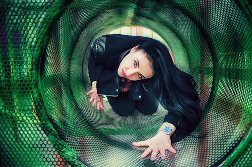 Brunette in Jacket Posing in a Playground Tunnel