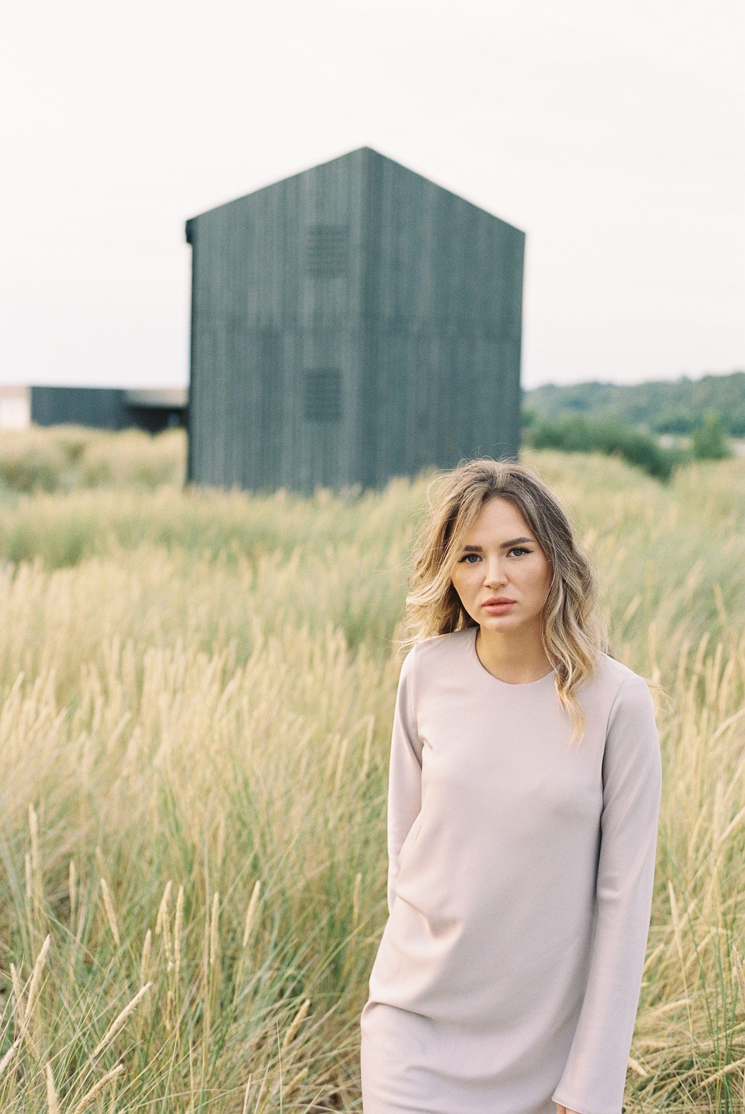 A Woman in White Long Sleeves Dress Standing on a Grass Field · Free ...