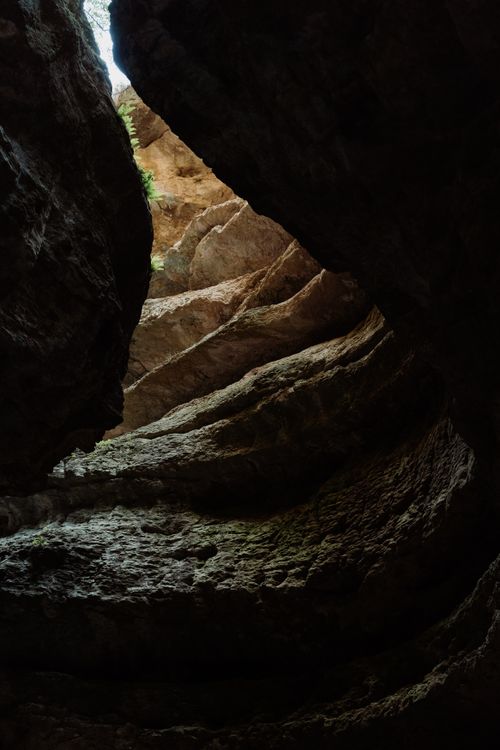 Free Explore the stunning geological formations and textures within a towering rocky cave. Stock Photo