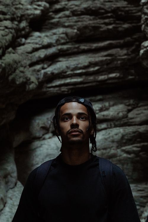 Free Portrait of a man exploring rugged rock formations in low light, embracing adventure. Stock Photo
