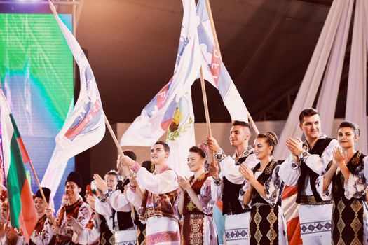 Vibrant celebration showcasing Romanian culture with traditional clothing and flags in Timișoara.
