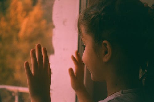 A Young Girl Looking at the Glass Window