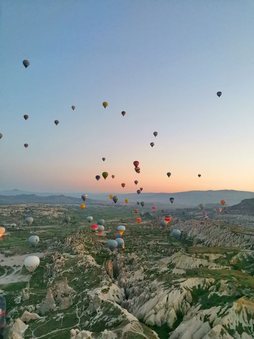 Free Stunning view of hot air balloons soaring above Cappadocia's unique landscape at sunrise. Stock Photo