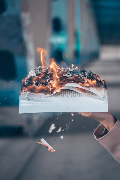 Close-Up Shot of a Person Holding a Burning Book