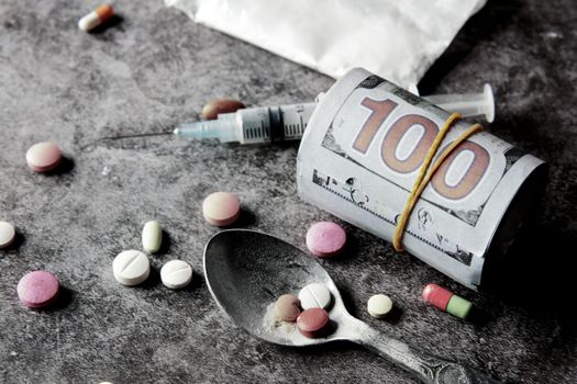 Symbolic representation of drug addiction and financial cost with pills and money.