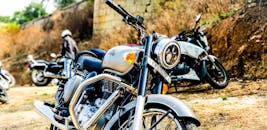 一辆经典摩托车与其他自行车一同停放在户外，特写镜头传达出冒险与自由的气息