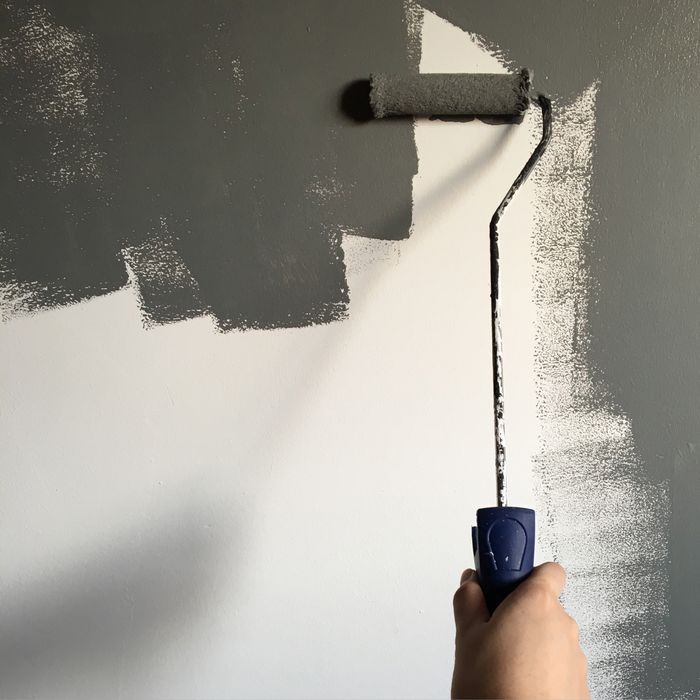 Professional painter using a roller to paint an interior wall