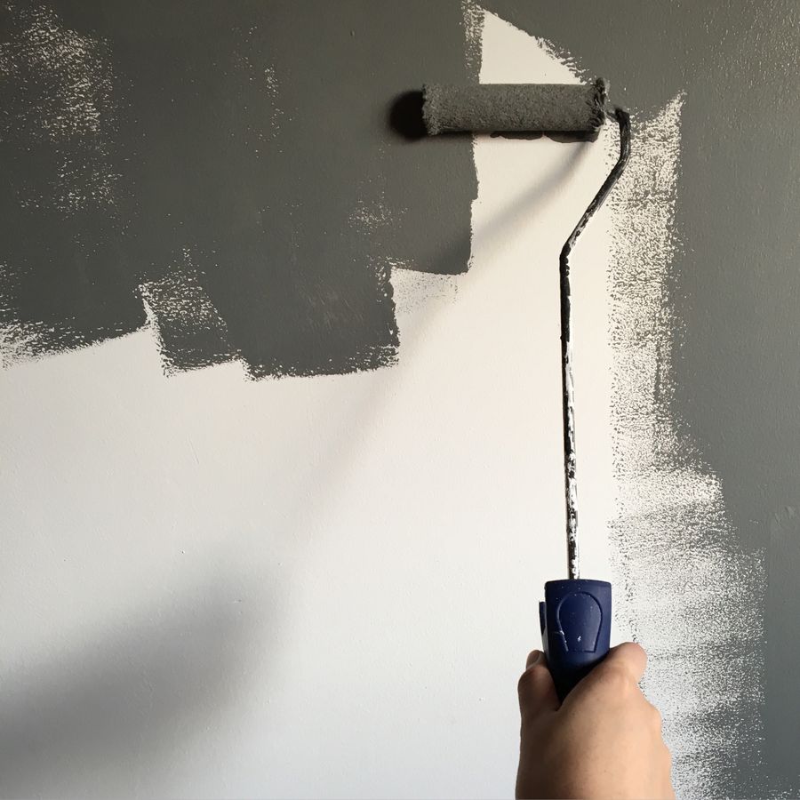 Applying paint to a wall with a roller