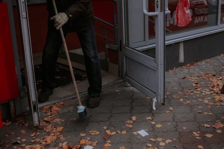 Person Sweeping Dry Leaves