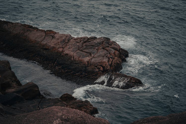 Gentle Sea Waves Bouncing Off Basalt Rocks At Sea Shore