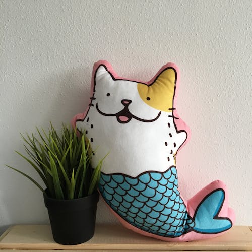 Mermaid Cat Pillow Beside Plant