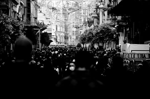 Monochrome view of a crowded urban street with people walking through the downtown district.