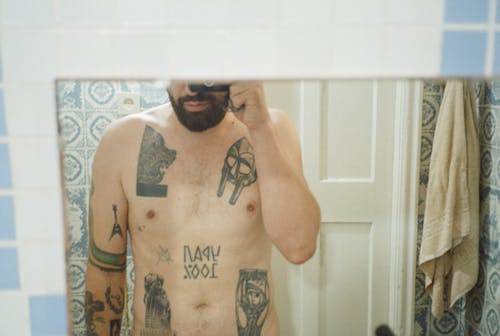 No Face Mirror Photo of Tattooed Man