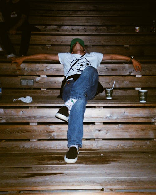 A Person in White Shirt Sitting on Wooden Bench