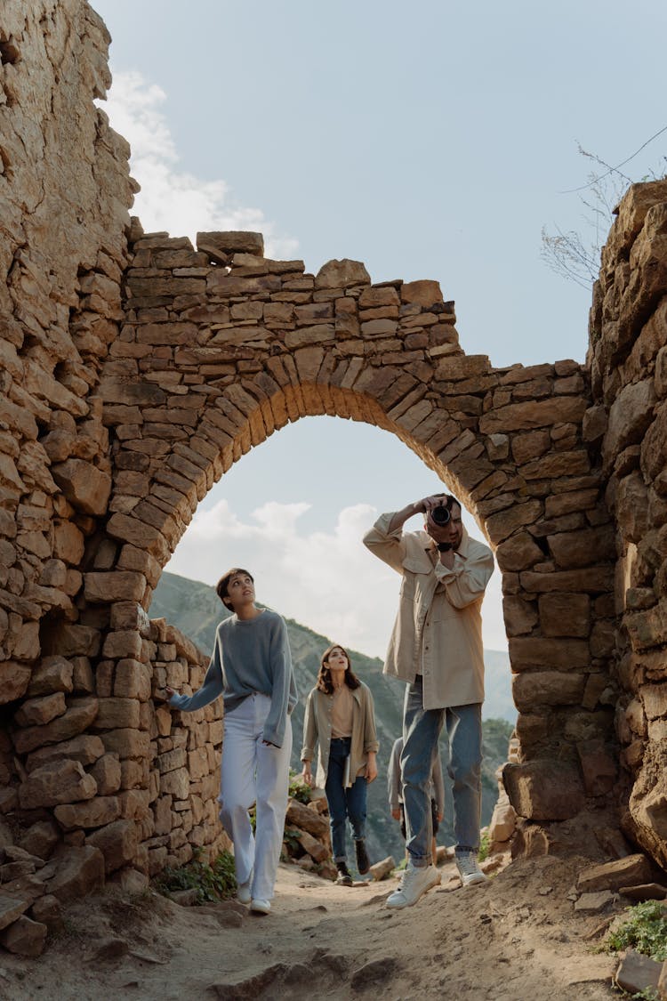 Group Of People Exploring Ruins Of Brick Walls