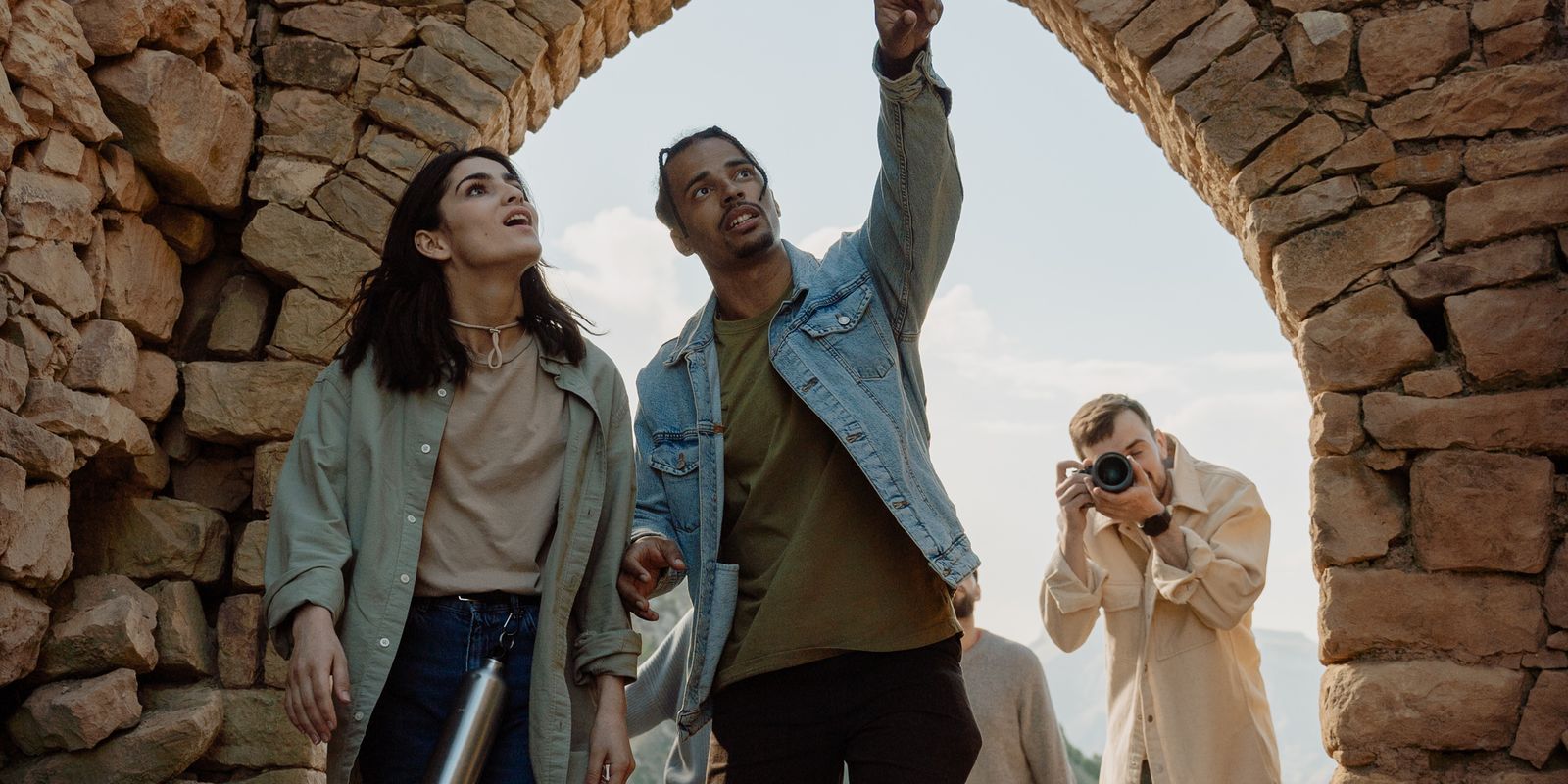 Group of tourists exploring ancient stone ruins with a photographer capturing the moment - archaeological sites