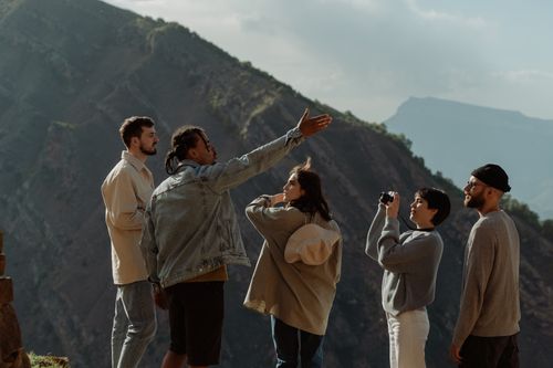Free A diverse group of young adults enjoys a scenic mountain view during a daytime adventure. Stock Photo