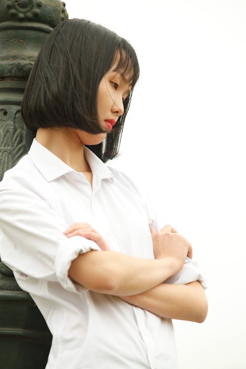 Free Woman Wearing White Dress Shirt Standing Near Concrete Statue Stock Photo