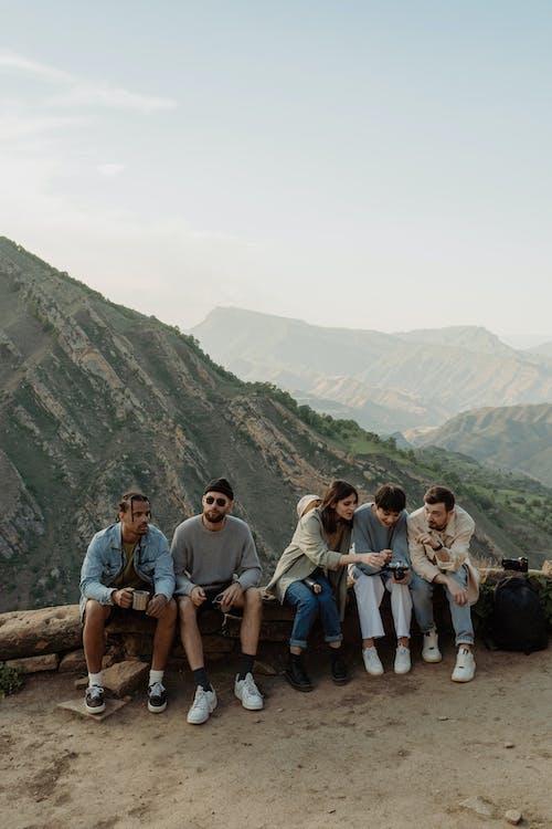 Group of People Sitting on a View Deck of a Mountain