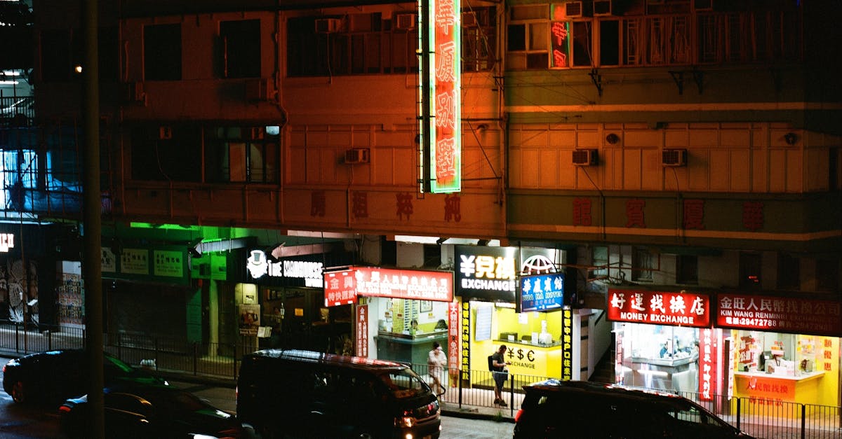 Photo by B.N.W Nighttime city street scene with neon lights and bustling traffic, capturing urban life.
