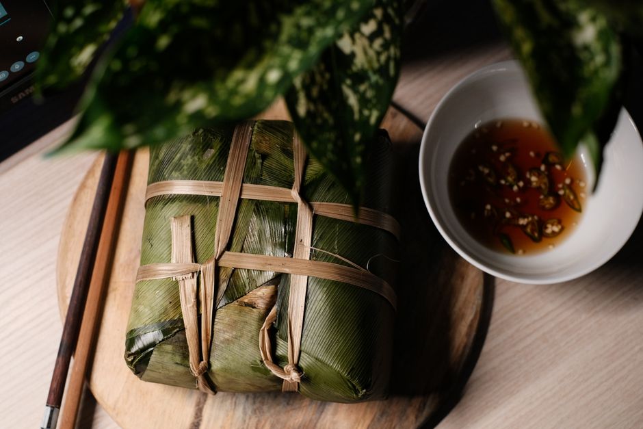 Delicious Vietnamese rice cake wrapped in leaves, paired with a savory dipping sauce.
