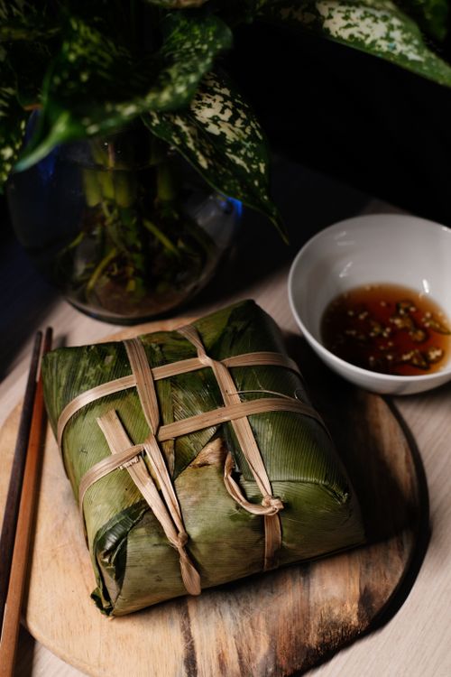 Free Explore this beautifully wrapped banana leaf dish paired with chopsticks and dipping sauce. Stock Photo