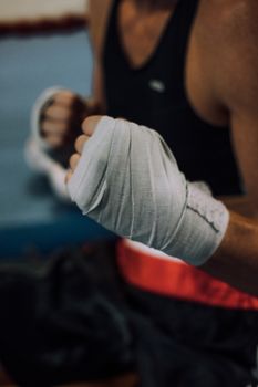 Close-up shot of a boxer's wrapped hands in a combat-ready pose.
