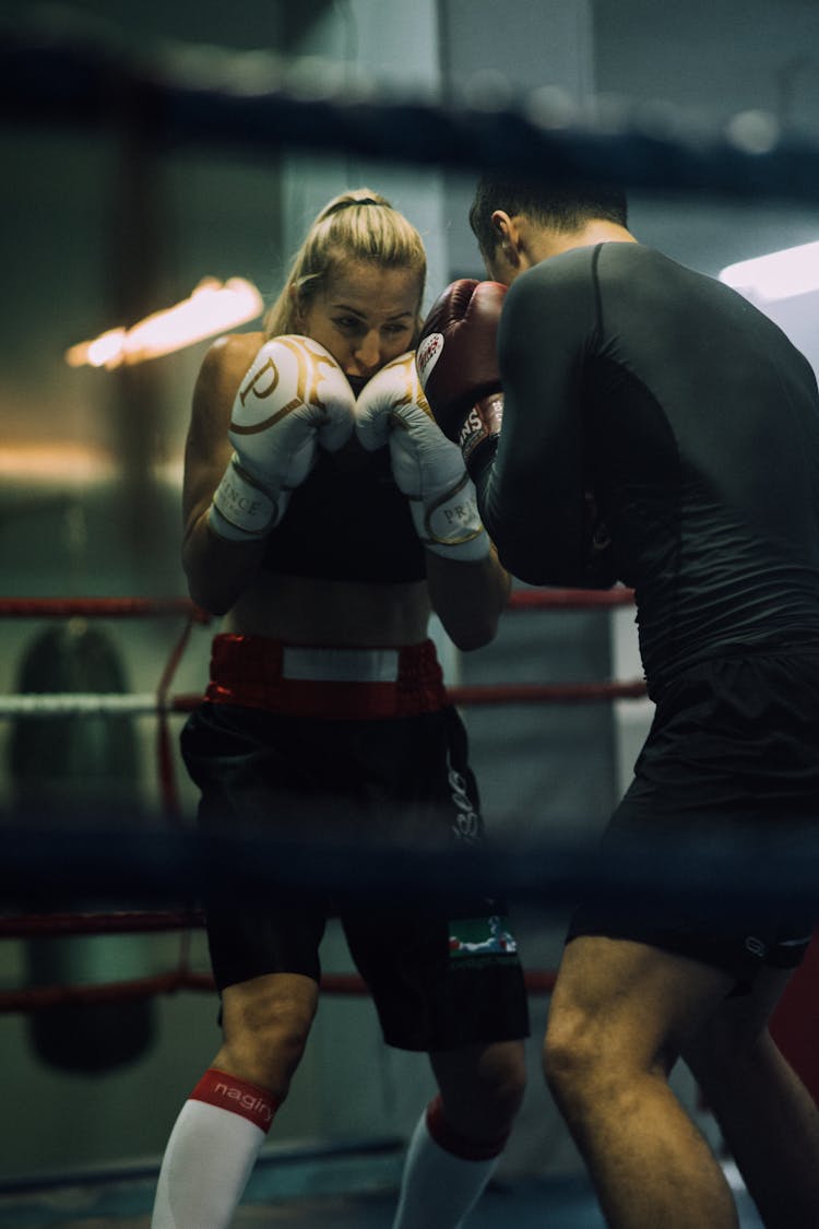 A Man And A Woman Sparring On A Boxing Ring