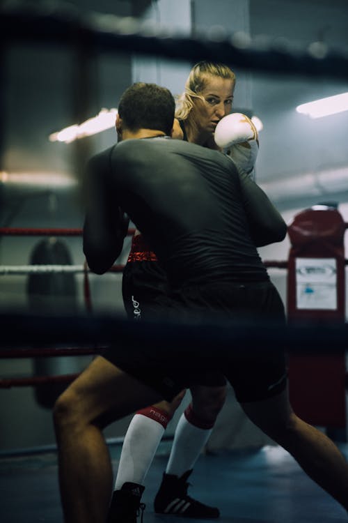 A Man and a Woman Sparring on a Boxing Ring