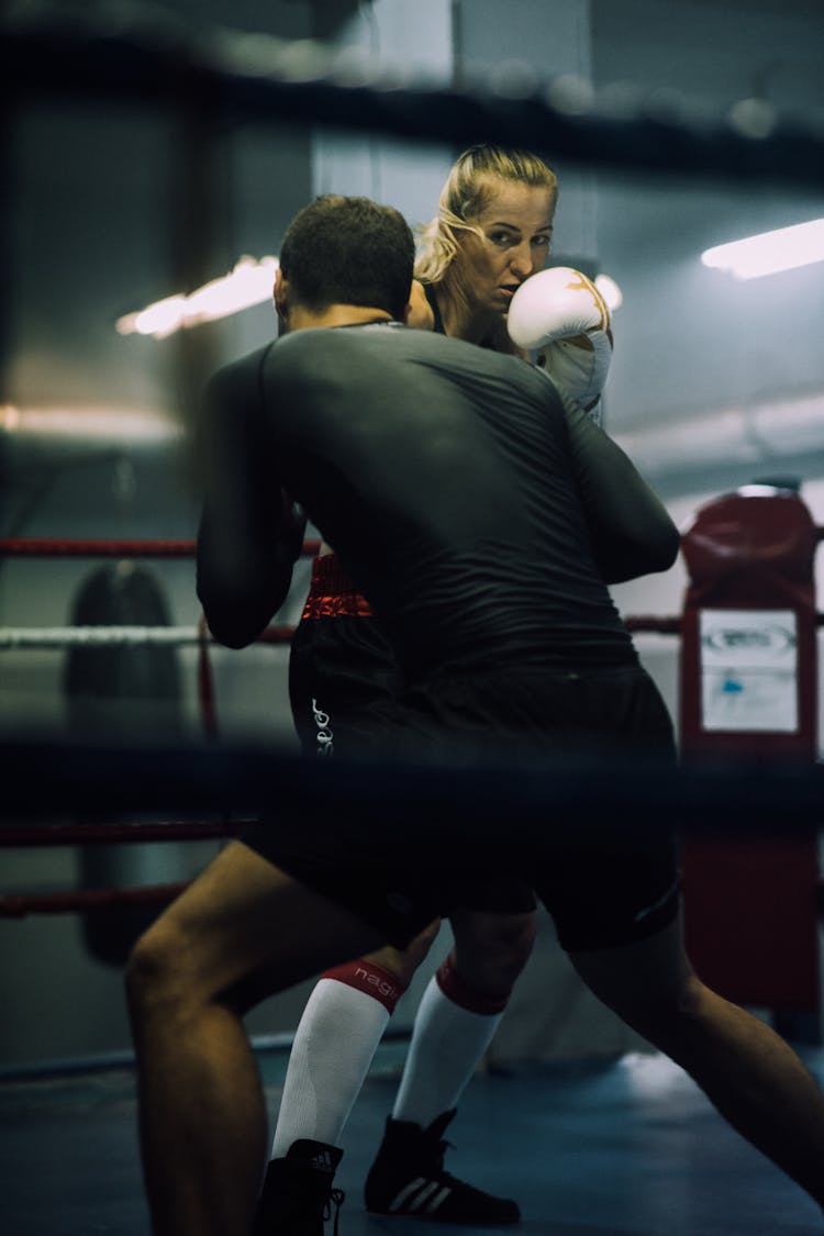 A Man And A Woman Sparring On A Boxing Ring